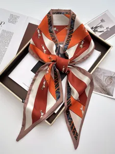 Macro shot of silk twilly scarf with horse print on a decorative brown tray