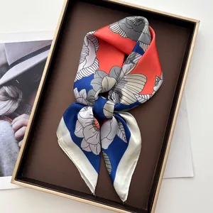 Détail d'un carré de soie à motifs floraux et fini satiné dans son coffret cadeau
