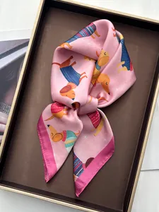 Dettaglio di un foulard in seta rosa con bassotti a cartoni e un bordo fucsia