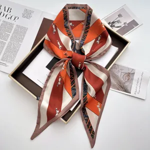 Macro shot of stylish twilly silk scarf with horse print on a luxury gold tray