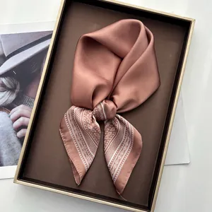 Detail of elegant dusty pink paisley silk scarf tied in a stylish gift display box