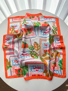 Detail eines Seidenschals mit Orangenscheiben und tropischen grünen Blattmustern