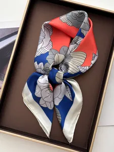 Carré de soie aux motifs floraux colorés présenté dans un coffret cadeau élégant et chic