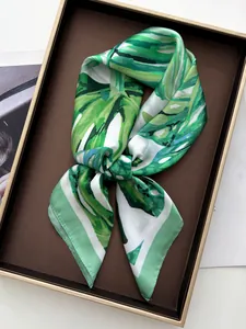 Detail view of tropical green monstera leaf print on smooth satin silk square scarf