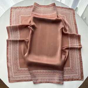 Detail of silk-satin scarf in cinnamon brown with white paisley border pattern