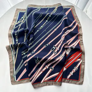 Detailed close-up of blue silk scarf with golden chain and red belt equestrian patterns