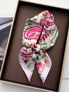 Vue détaillée d'un foulard en soie imprimé cachemire coloré sur un plateau de présentation chic