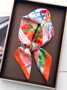 Detail des Seidenschals mit Orangen-Fruchtmustern und blau kariertem Rand-Design
