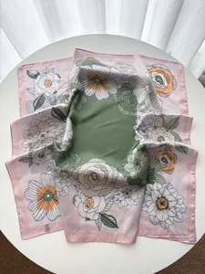 Gros plan détaillé du foulard carré en soie à imprimé floral avec centre vert olive
