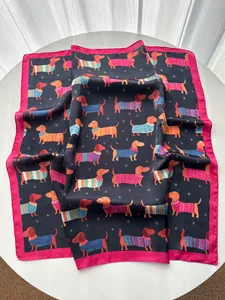 Dettaglio di un foulard in seta con stampa bassotto e vivaci bordi rosa acceso