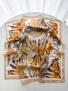 Close-up of tropical palm leaf print silk scarf with golden yellow and emerald green tones