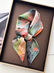 Close-up of artistic floral silk scarf with vibrant abstract print in a premium gift box