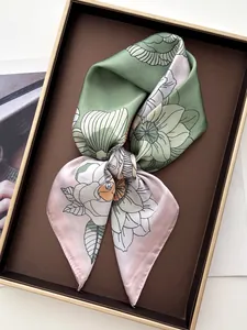 Gros plan d'un carré de soie à imprimé floral dans un coffret cadeau de luxe