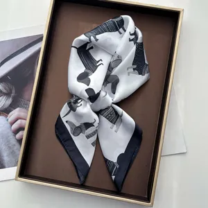 Dettaglio del foulard di seta con stampa bassotto bianco e nero su vassoio in metallo