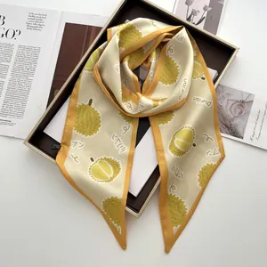 Vue détaillée d'un foulard en soie à imprimé durian plié dans une boîte cadeau