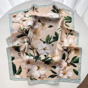 Detail view of floral satin square scarf with elegant blossom print and mint green border