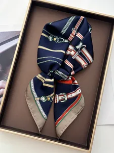 Detail view of silk scarf with navy horse bit chain print and gold buckle accents