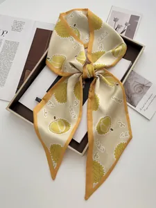 Détail du foulard jaune avec imprimés de fruits Durian et motifs graphiques élégants