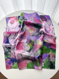 Detailed view of floral silk scarf featuring pink flowers, green leaves and dragonflies