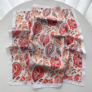 Détail d'un foulard carré en soie à motif paisley avec des bords roulés de haute qualité
