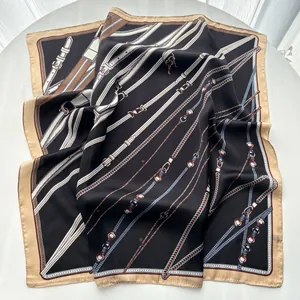 Detail of silk square scarf featuring equestrian chain and belt patterns in black and gold