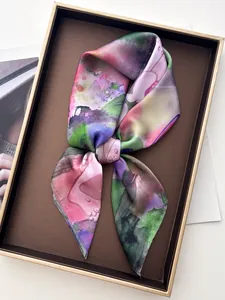 Close-up of vibrant floral silk scarf with abstract watercolor pattern in a gift tray