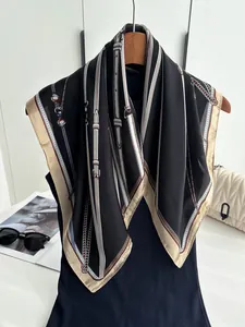 Silk scarf styled on hanger with classic chain and belt print in black and champagne
