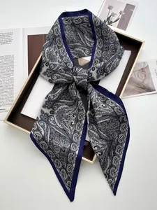 Detailed flat lay of navy blue paisley silk scarf with white pattern and satin finish
