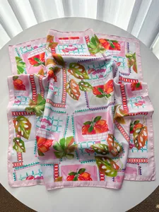 Detailansicht eines Seidenschals mit lebhaften Zitrusfrucht- und grünen Palmenblatt-Prints