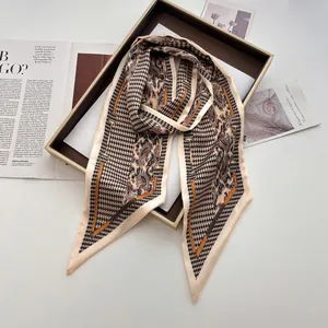 Close-up of silk scarf with houndstooth and paisley patterns in a gift box packaging