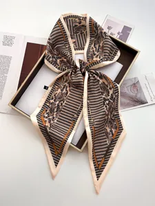 Detail of satin scarf with houndstooth and paisley patterns in apricot and black