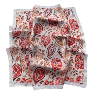 Carré de soie élégant avec motifs paisley orange et rouge sur un fond blanc pur