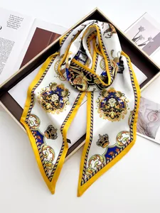 Detail of luxury silk scarf with baroque crown print and gold finish on a tray