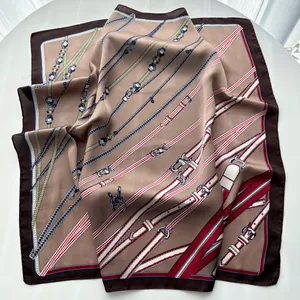 Detailed close-up of brown silk scarf with equestrian chain and leather belt patterns