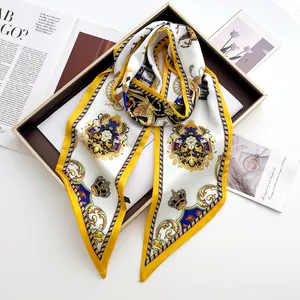 Detail of luxury satin scarf with vintage crown print and horse motif on brown tray