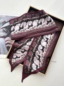 Close-up of a vintage horse chain silk twilly scarf in a luxury gift box packaging