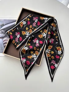 Détail d'un foulard en satin à fleurs avec pointes et texture de soie douce sur plateau