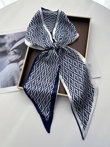 Detailed close-up of a blue and white patterned silk satin scarf with a rhombus print