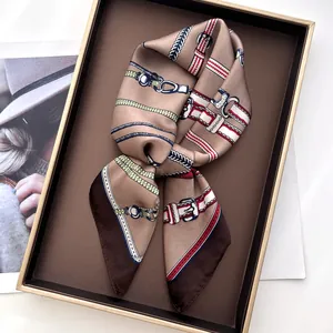 Close-up of luxury silk scarf with vintage chain print folded in premium gift box