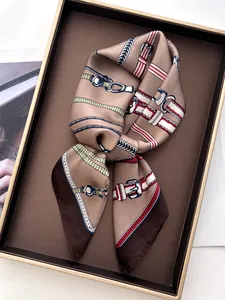 Detailed view of luxury chain belt print silk scarf folded in a gift box