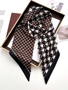 Detail of coffee houndstooth and geometric star print silk scarf in premium gift box