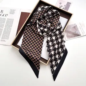 Detail of houndstooth silk scarf with geometric patterns in a luxury gift box packaging