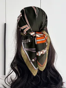 Detail of dark green silk scarf with chain print styled as a headband on black hair
