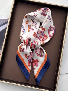 Detail of silk scarf with orange rocking horse print and elegant knotted styling