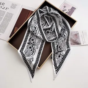 Detail eines eleganten schwarz-weißen Seidenschals mit Paisley-Muster und Satinstruktur