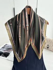 Detail of dark green silk scarf with golden chain and horse bit patterns on a hanger