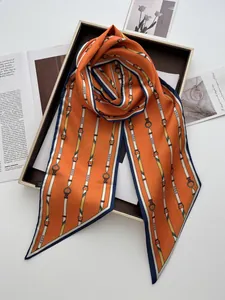 Dettaglio di un foulard in seta con stampa a fibbia su un vassoio dorato