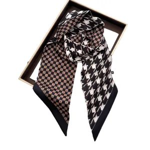 Chic houndstooth and star pattern satin twilly scarf draped over a gold frame on white