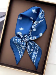 Close-up of royal blue silk scarf with white paisley print on a luxury display tray