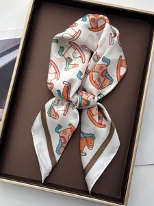 Detail of silk square scarf featuring cartoon rocking horse prints on a display tray